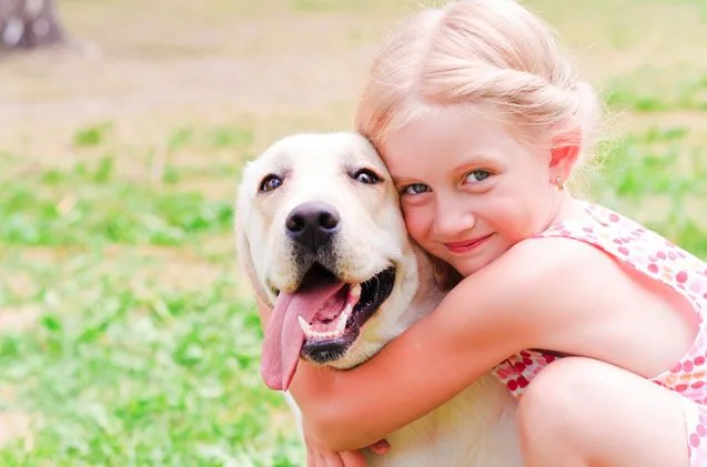 Une fillette serre un chien dans ses bras