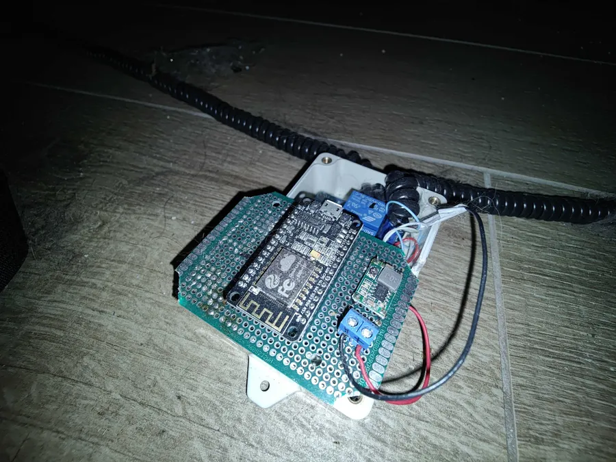 Carte ESP32 et relais montés sur une plaque, câblés sous le canapé